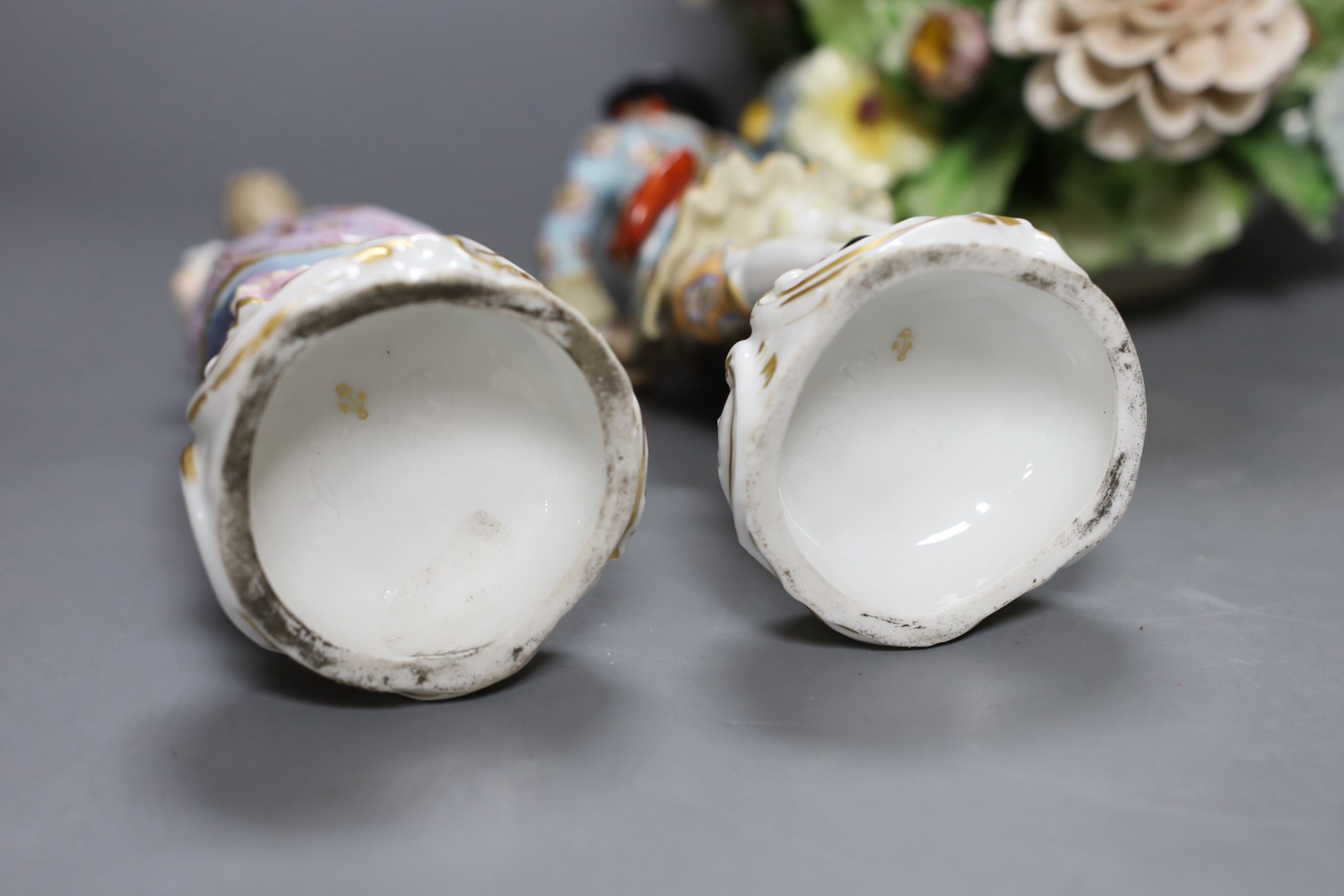 A pair of Continental porcelain figures and a Naples flowers bouquet. 22cm tall